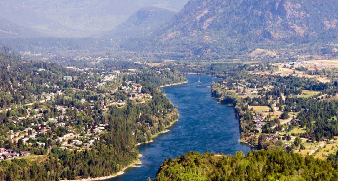 Scenic river view with bridge and mountains.