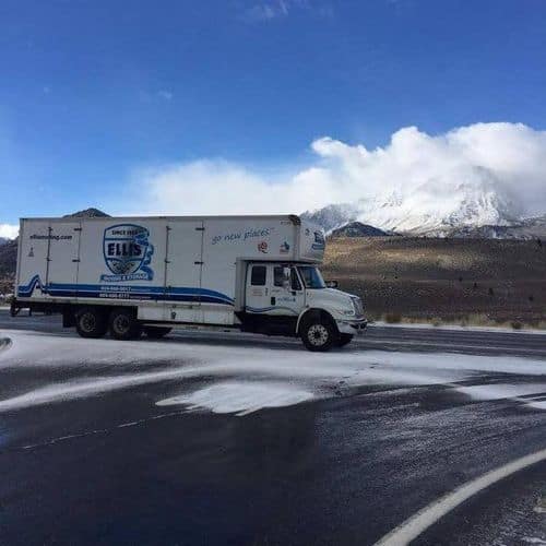 Moving truck on snowy mountain road