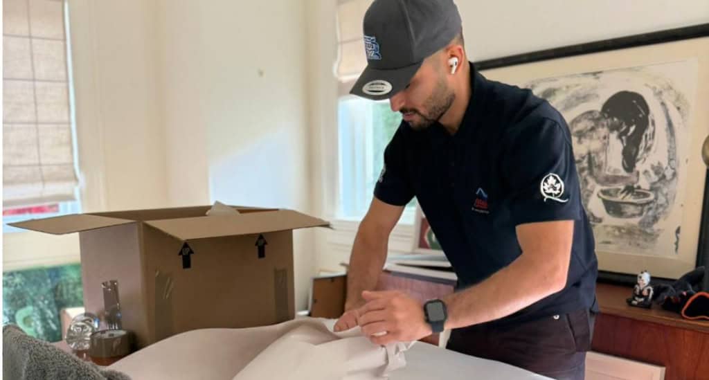 Man packing a box in the living room.