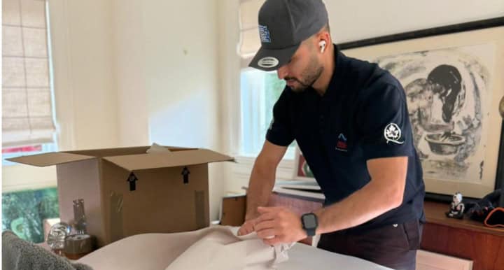 Man packing a box in the living room.